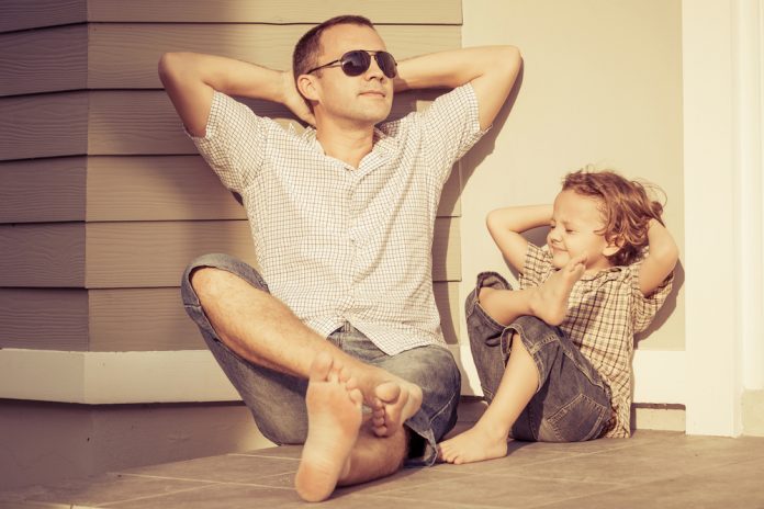 rituale für ein entspranntes familienleben Vater und Kind sitzen entspannt auf dem Boden