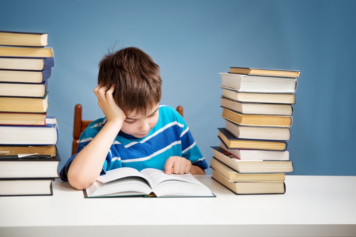 Lesen-Bub-Bücherstapeln Bub mit Bücherstapel lesend