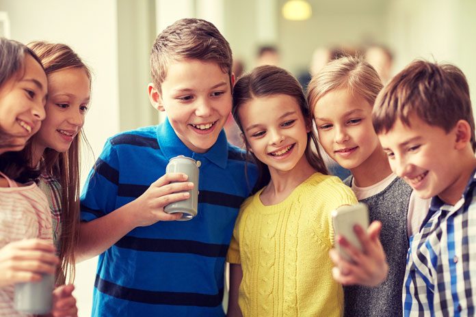 medien-tipps-eltern Schulkinder schauen auf ein Handy