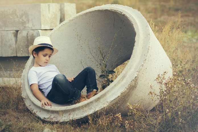 natur-kinder Kind sitzt in Betonreifen