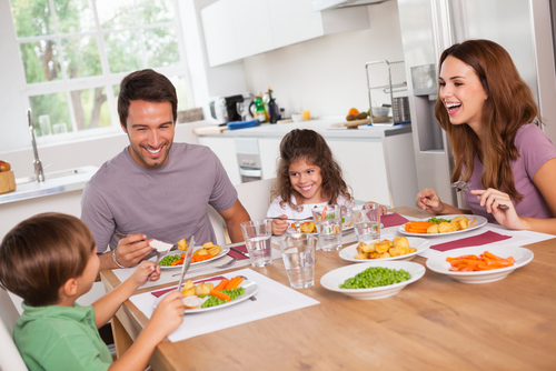 Famile lacht biem Mittagessen 124589956