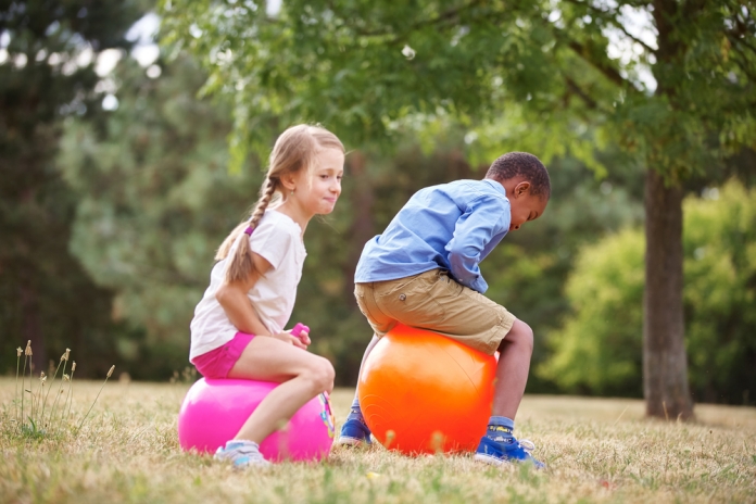 Ferienbetreuung 346595657 2 Kinder spelen mit dem Hüfpball