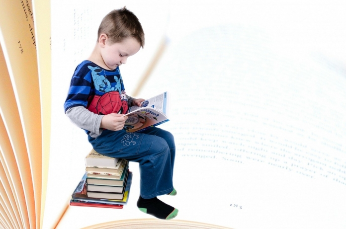 child-316511_1280 Kind sitz auf einem Stapel Bücher